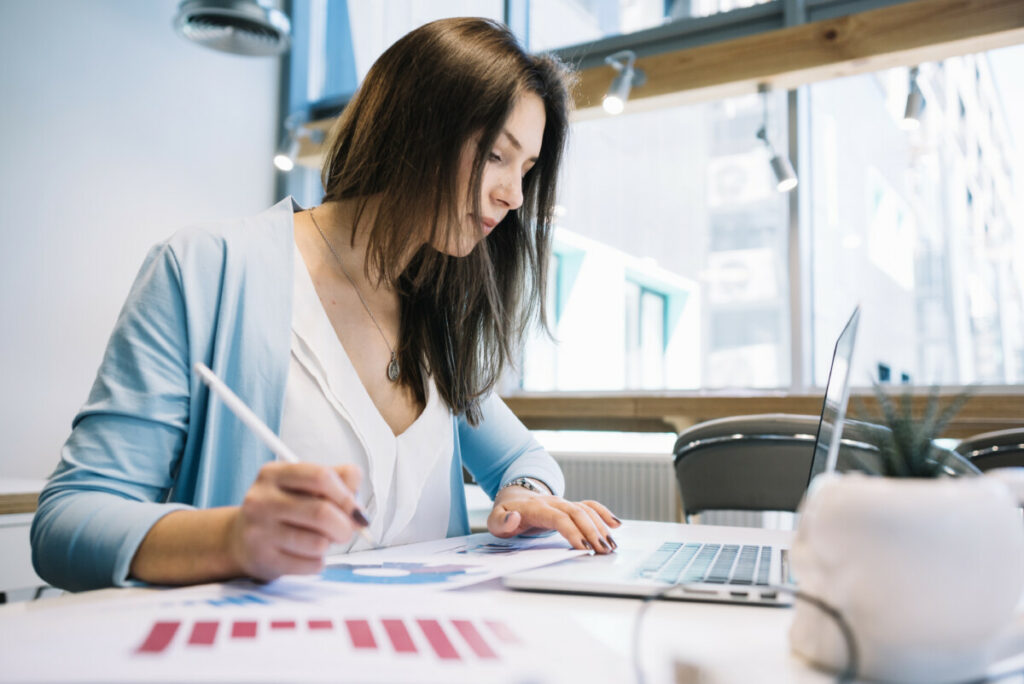 Professionnelle focalisée sur des analyses graphiques, utilisant un logiciel de facturation gratuit sur son ordinateur portable